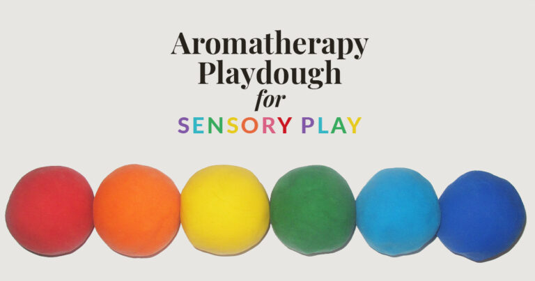 Image showing six colorful balls of aromatherapy playdough in red, orange, yellow, green, light blue, and dark blue, arranged in a row beneath the text 'Aromatherapy Playdough for Sensory Play.' The words 'Sensory Play' are written in rainbow colors, highlighting the playful and sensory-focused nature of aromatherapy playdough.